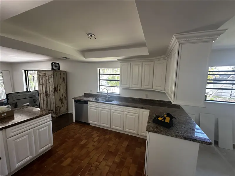 Kitchen with white raised-panel cabinets refinished with a smooth, clean finish
