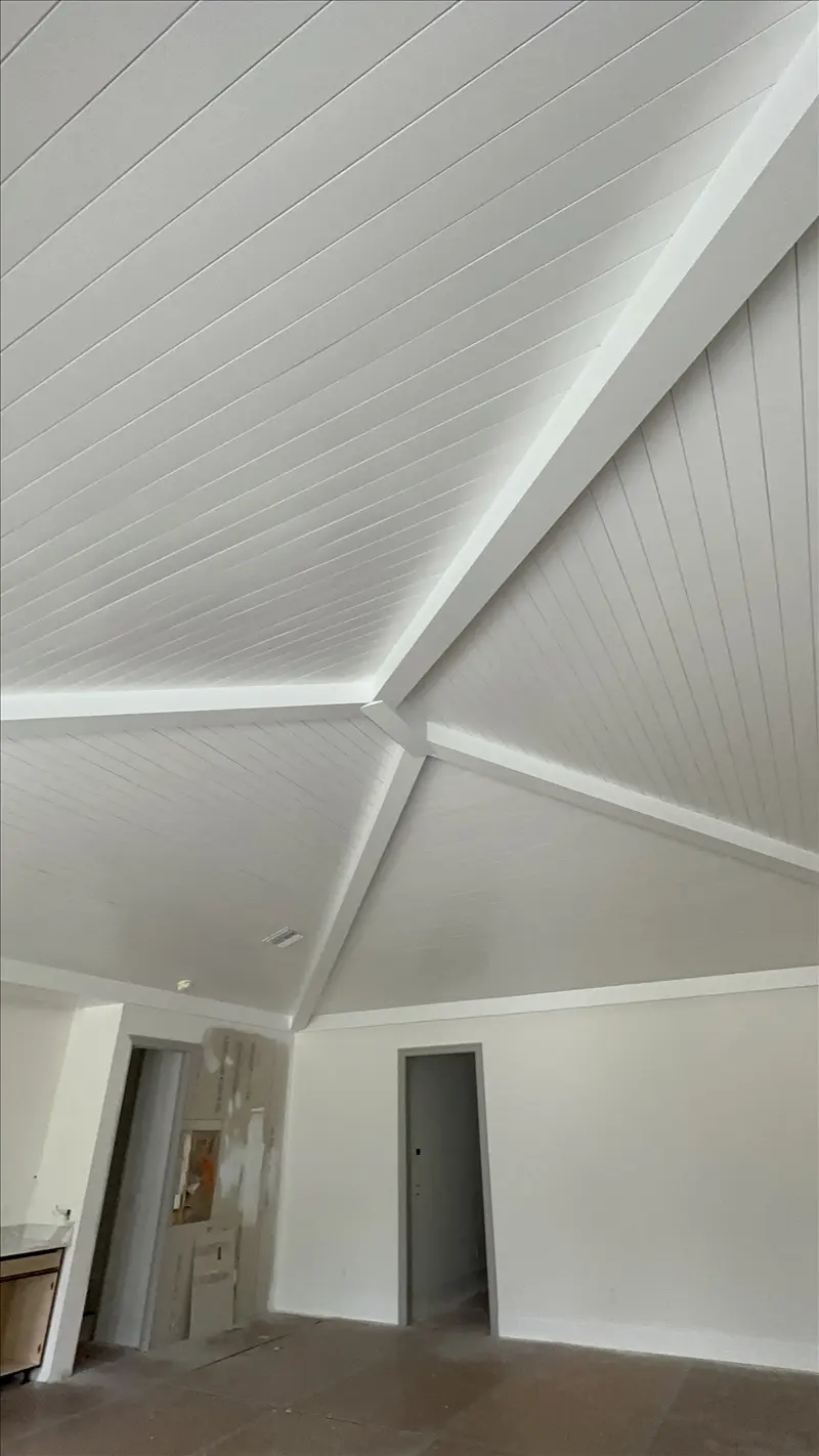 Vaulted shiplap ceiling with white painted beams and clean wall lines