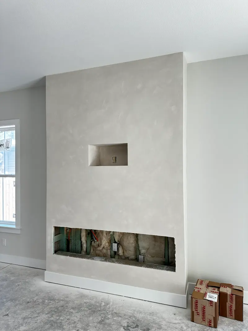 Tall fireplace wall finished in soft, cloudy limewash with a recessed niche